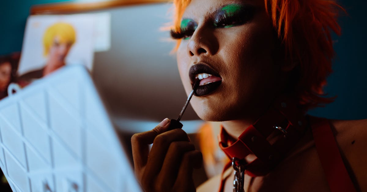 Can I remove some of the strange attributes from a strange cosmetic? - Crop funky woman applying black lipstick