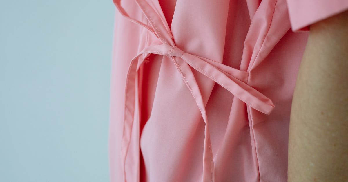 Can I save everyone in one day? - Crop unrecognizable female patient in pink gown with pink ribbon standing against white background