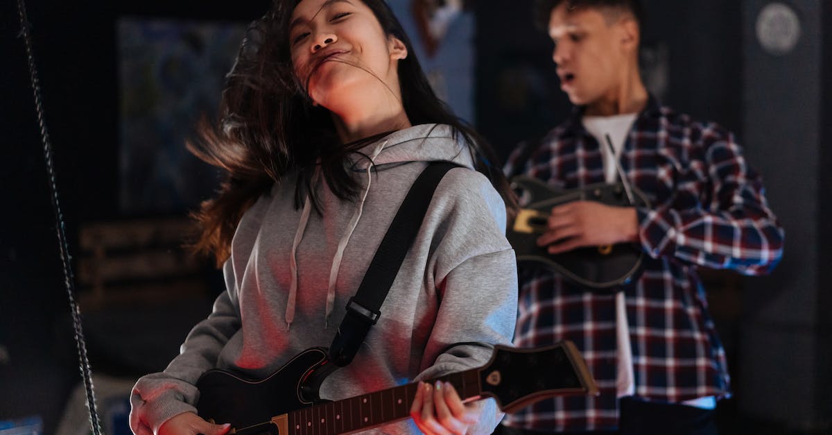 Can I sync a Guitar Hero World Tour controller dongle with a Guitar Hero 3 guitar? - Woman in Gray Sweater Holding Brown Electric Guitar Can I sync a Guitar Hero World Tour controller dongle with a Guitar Hero 3 guitar? - Woman in Gray Sweater Holding Brown Electric Guitar