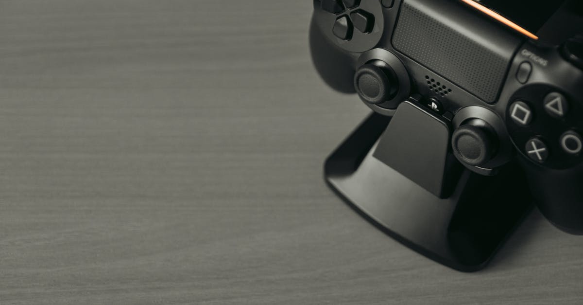 Can I transfer downloaded games on ps4 - Black Game Controller on Brown Wooden Table