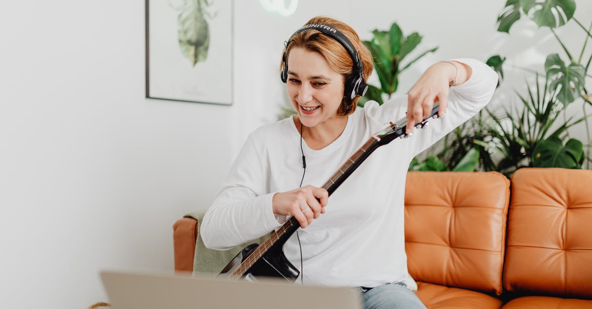 Can I use a Wii Guitar Hero Guitar on PC? - Woman with Headphones Giving Online Guitar Classes Can I use a Wii Guitar Hero Guitar on PC? - Woman with Headphones Giving Online Guitar Classes
