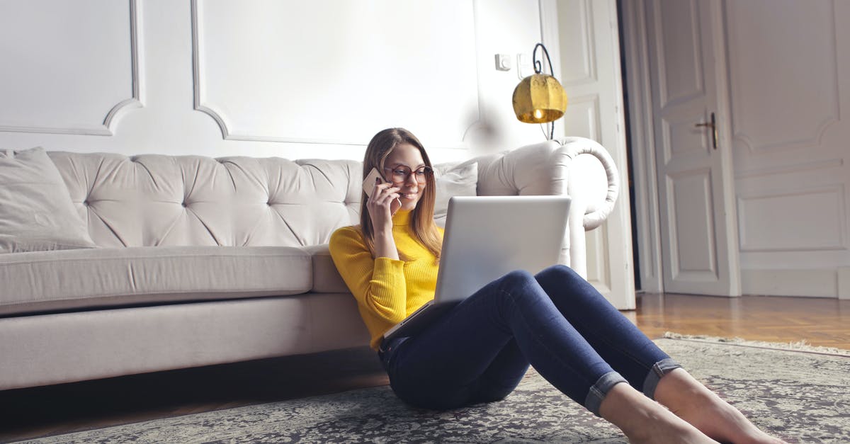 Can I use Steam Family Sharing with five user accounts plus one account per game? - Smiling barefoot female in glasses and casual clothes using laptop and having phone call while sitting on floor leaning on sofa and working on laptop against luxury interior of light living room