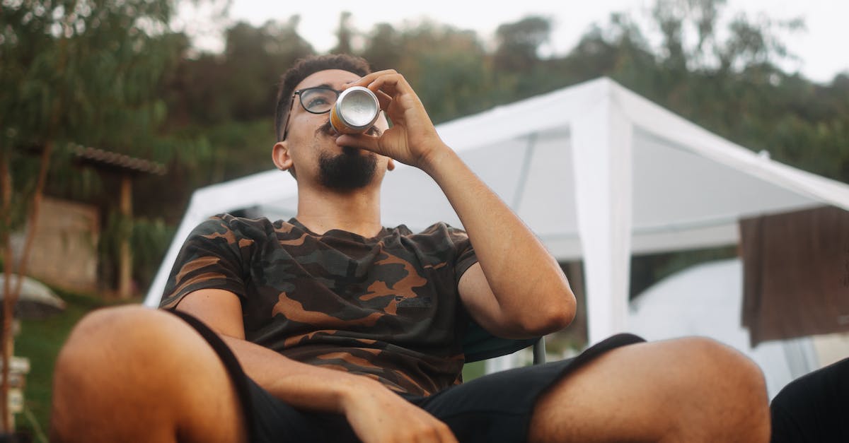 Can I visit my own garrison with an alt? - Man in Black and Brown Camouflage Shirt Drinking From a Can 