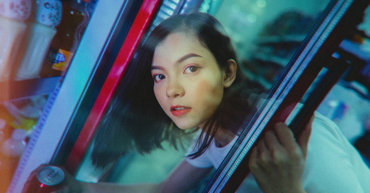Can my companions take items out of legacy storage? - Calm ethnic woman taking refreshing drink from refrigerator in shop