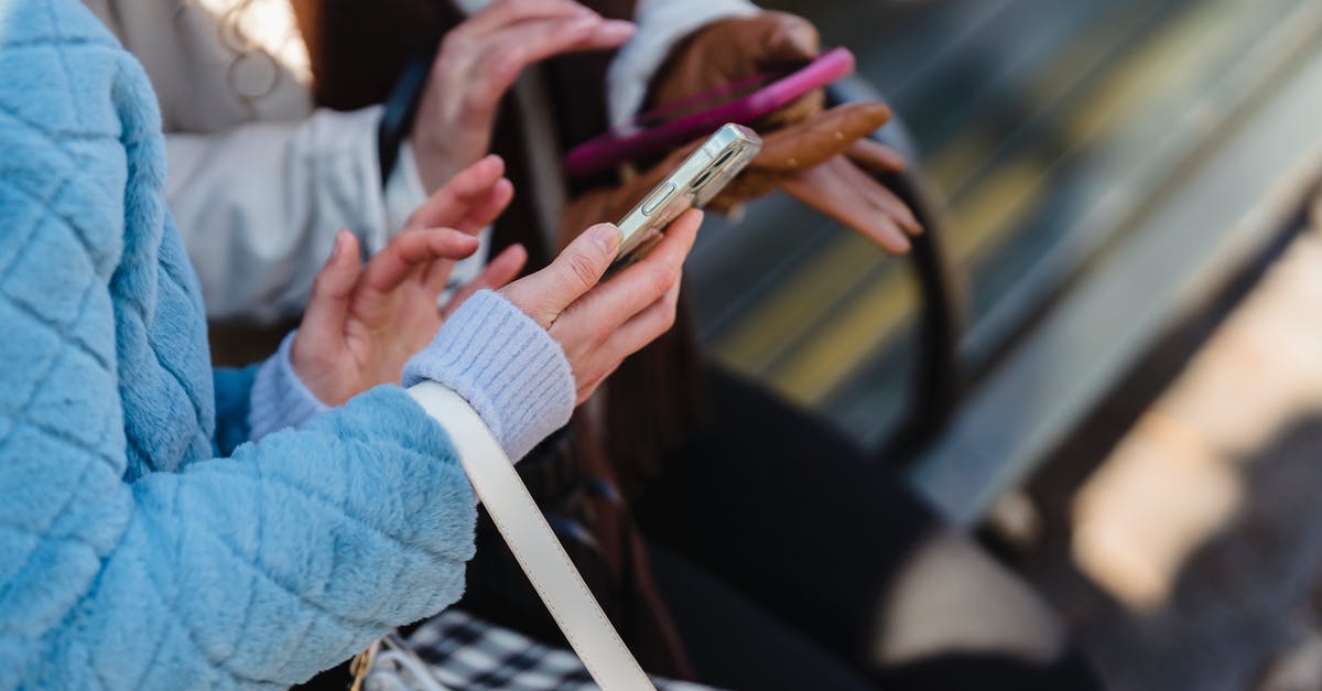 Can my friend play Street Fighter V online from shared library? - From above of crop anonymous friends sharing information on mobile phones in park in daytime on blurred background Can my friend play Street Fighter V online from shared library? - From above of crop anonymous friends sharing information on mobile phones in park in daytime on blurred background