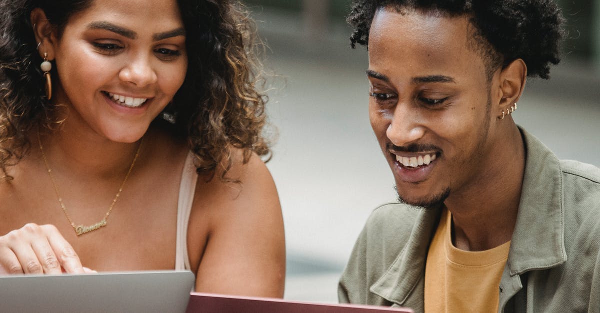 Can my friend play Street Fighter V online from shared library? - Happy young diverse students surfing netbooks on street Can my friend play Street Fighter V online from shared library? - Happy young diverse students surfing netbooks on street