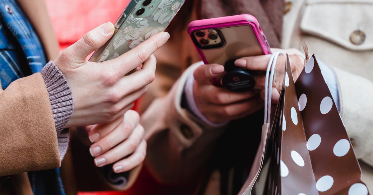Can my friend play Street Fighter V online from shared library? - Unrecognizable ladies messaging smartphones on street Can my friend play Street Fighter V online from shared library? - Unrecognizable ladies messaging smartphones on street