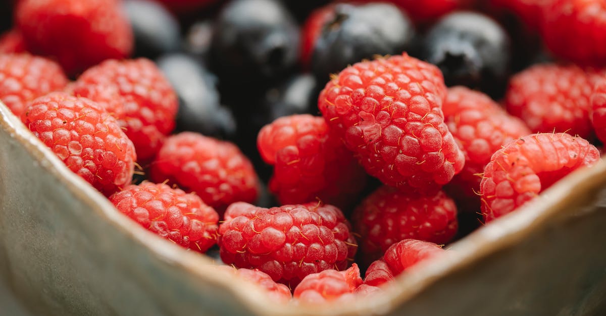 Can Pokemon eggs pile up while to collect in the Day Care? - Mix of wild raspberries and blueberries collected in forest and placed in bowl in countryside with blurred background in summer