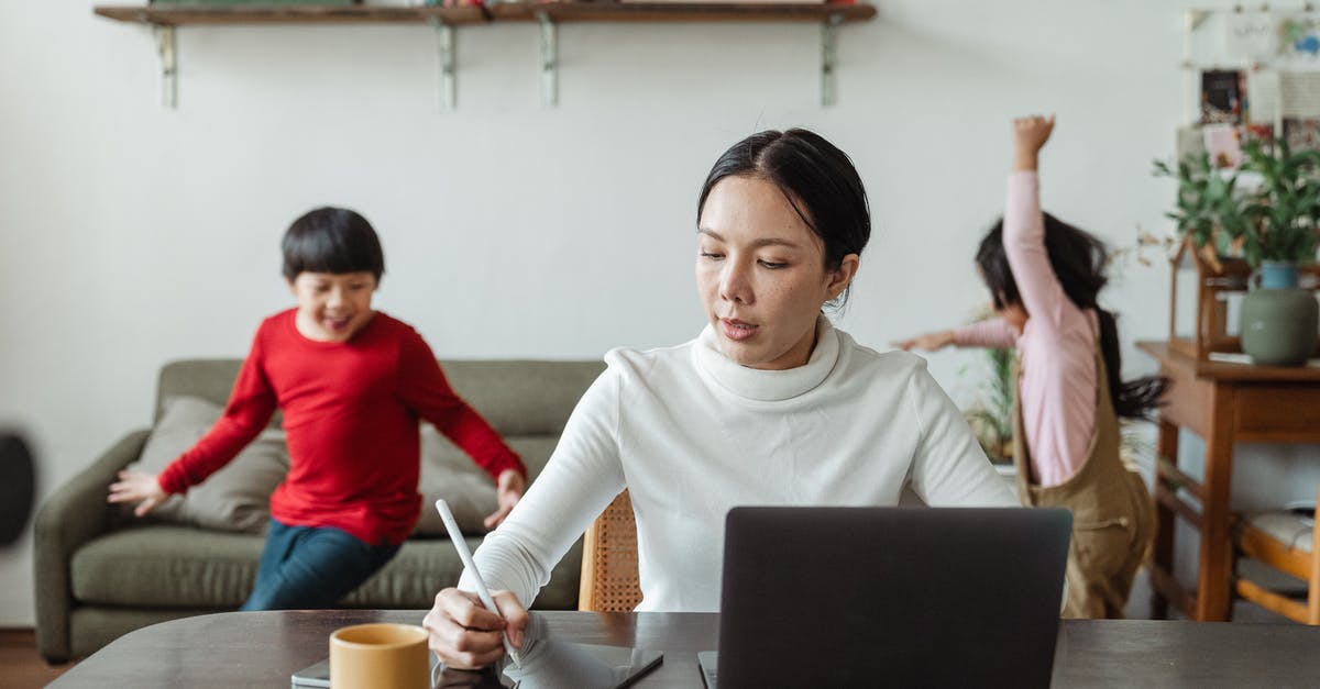 Can pokemon run while taking a picture? - Asian mother working online using laptop and taking notes on tablet with stylus and cheerful children making noise and running behind in living room