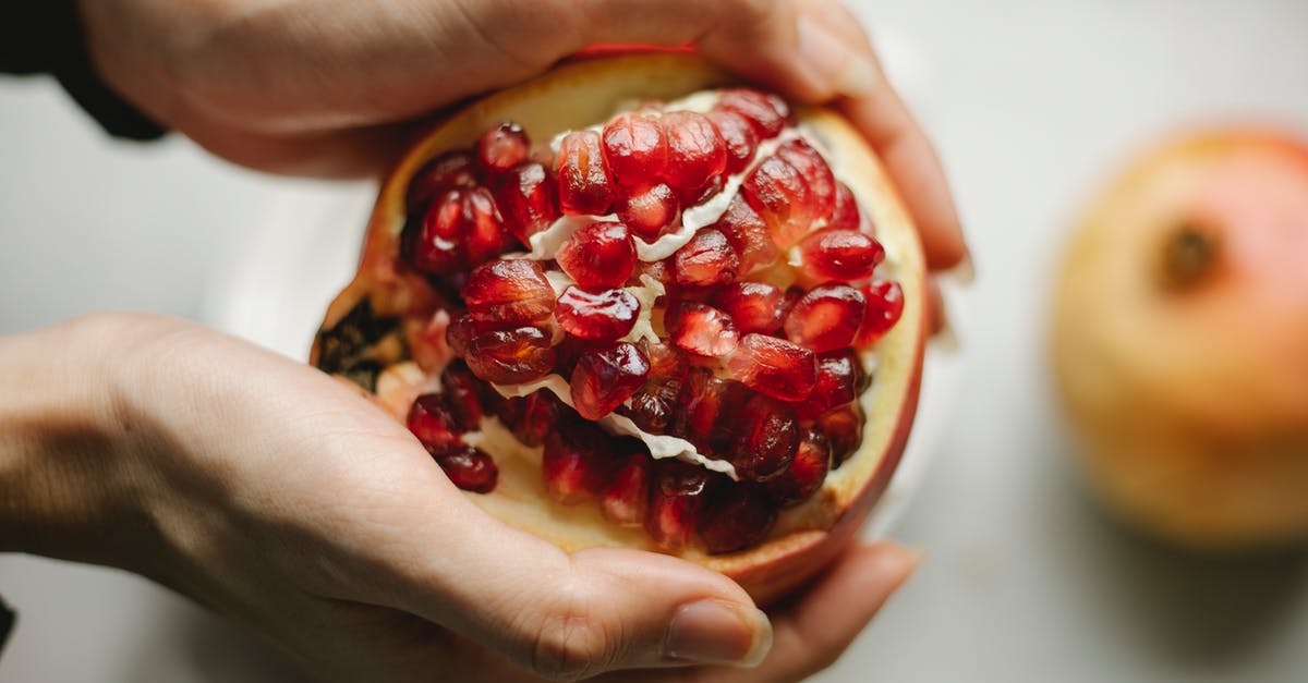 Can seed show up in a place where similar seed already show up? - Fresh pomegranate in hands of woman Can seed show up in a place where similar seed already show up? - Fresh pomegranate in hands of woman