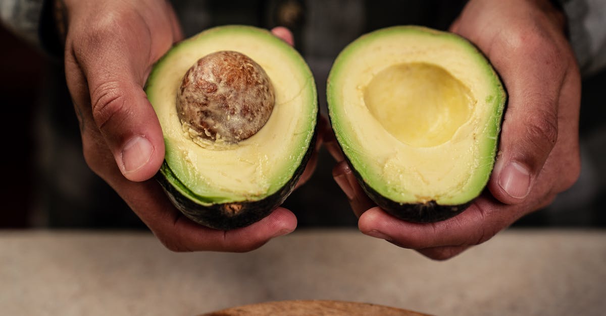 Can seed show up in a place where similar seed already show up? - High angle of crop anonymous male demonstrating ripe halved avocado while standing at table Can seed show up in a place where similar seed already show up? - High angle of crop anonymous male demonstrating ripe halved avocado while standing at table