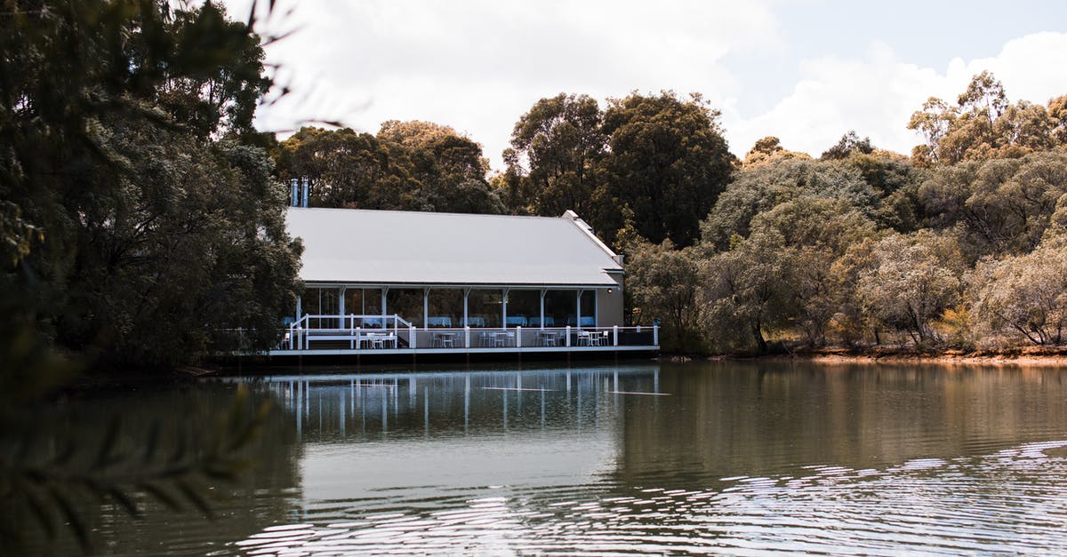 Can the Massachussets State House be [CLEARED]? - Building exterior against lake with rippling water surrounded by lush trees under cloudy sky in Florida