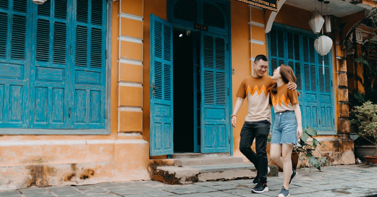 Can the same enemy in the same battle have more hp than other enemy of the same type? - Full length of happy Asian couple in same t shirts hugging and looking at each other while walking on street near entrance of colorful building