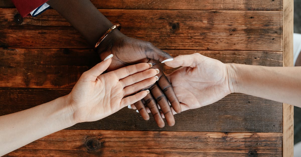 Can two accounts share the same game client with different licenses? - Diverse women stacking hands on wooden table Can two accounts share the same game client with different licenses? - Diverse women stacking hands on wooden table