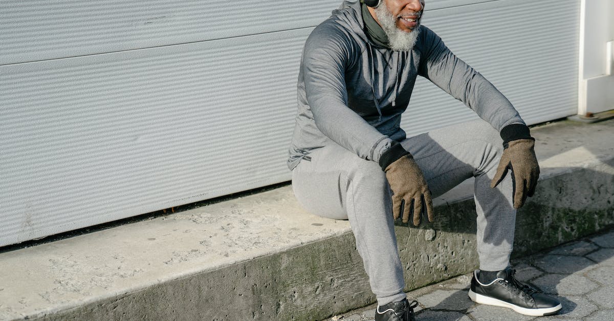 Can you add an old active account to a new device that has an active account already - Stylish mature black man sitting on street curb Can you add an old active account to a new device that has an active account already - Stylish mature black man sitting on street curb