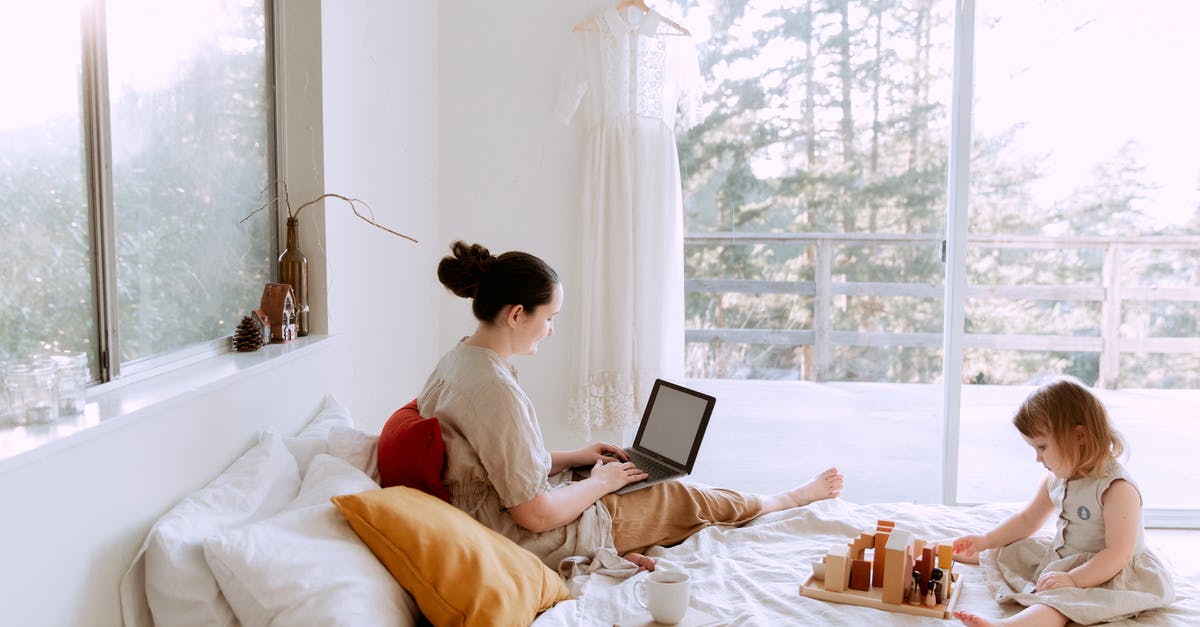 Can you play online with a game bought on a none online subscription account in Switch? - Side view of cute toddler girl sitting on bed barefoot and playing with colorful wooden blocks while mother using laptop in bed enjoying morning coffee