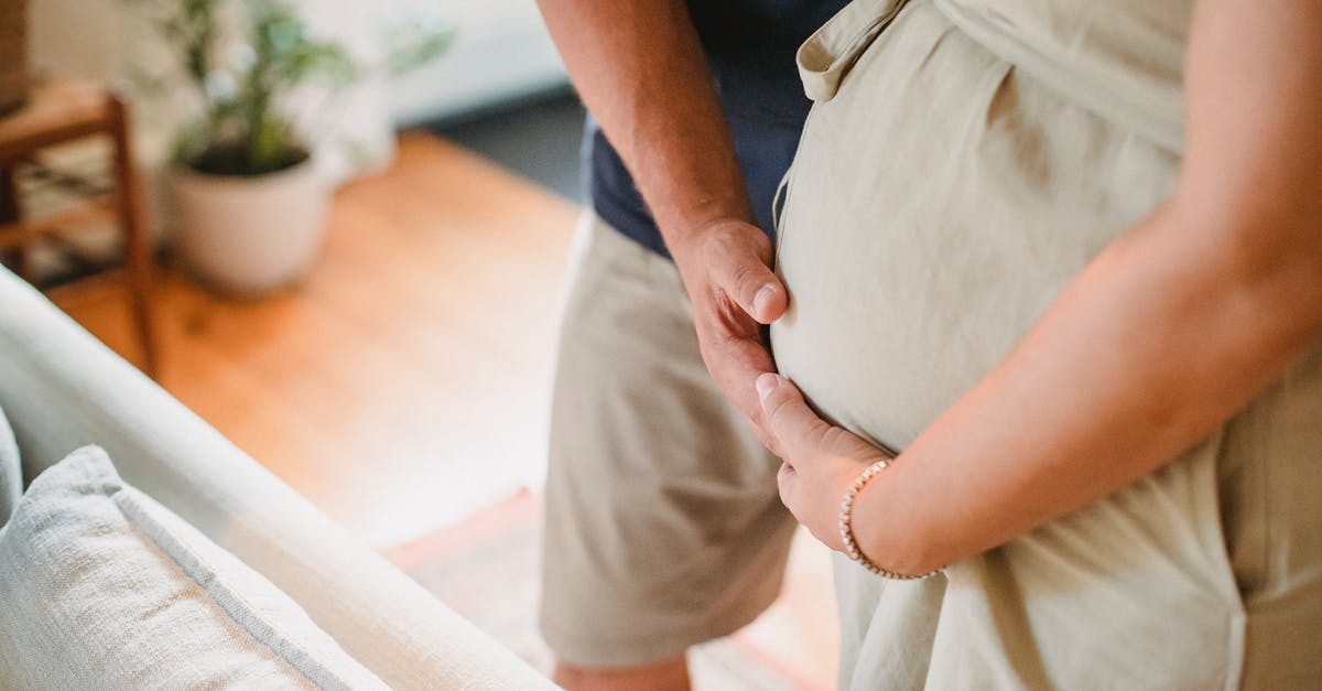 Can you remove a mom and dad from the living quarters once the mom is pregnant? - From above of crop faceless couple in casual outfit standing in light living room and touching pregnant belly gently Can you remove a mom and dad from the living quarters once the mom is pregnant? - From above of crop faceless couple in casual outfit standing in light living room and touching pregnant belly gently
