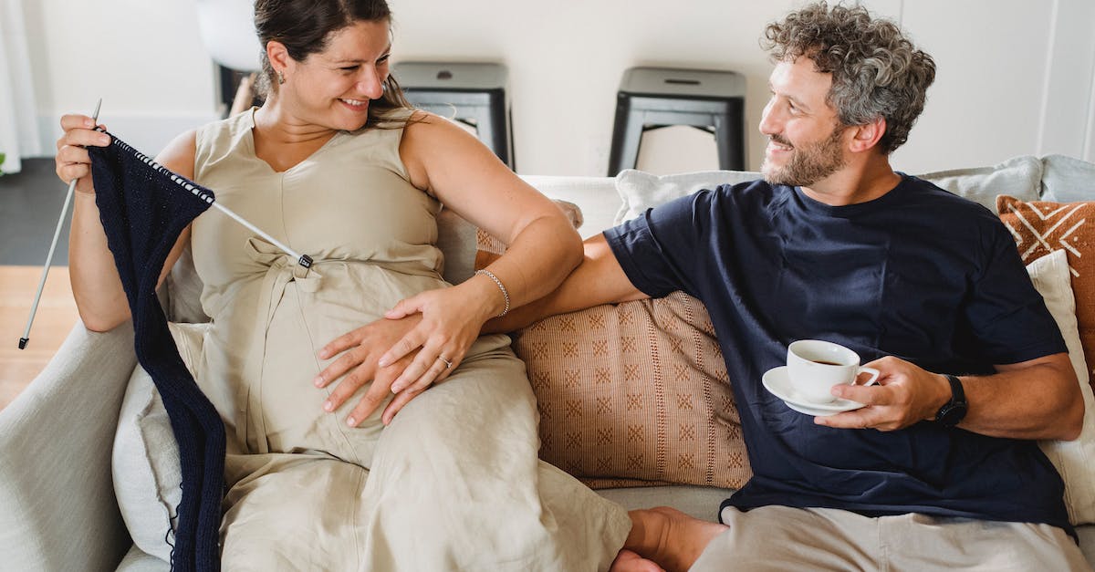 Can you remove a mom and dad from the living quarters once the mom is pregnant? - From above of smiling adult bearded man sitting on couch with hot coffee and touching pregnant belly of happy wife with knitting needles Can you remove a mom and dad from the living quarters once the mom is pregnant? - From above of smiling adult bearded man sitting on couch with hot coffee and touching pregnant belly of happy wife with knitting needles