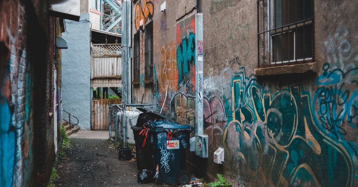 Can you summon during regular battles in Final Fantasy VII Remake? - Garbage can on narrow street between aged houses with graffiti on shabby walls in town