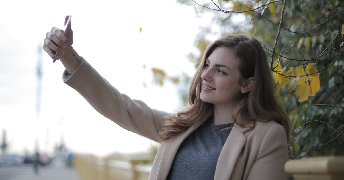 Can you use a bow to shoot specific arrows? (1.8.9) - Young woman in coat taking selfie with smartphone on street in overcast weather Can you use a bow to shoot specific arrows? (1.8.9) - Young woman in coat taking selfie with smartphone on street in overcast weather