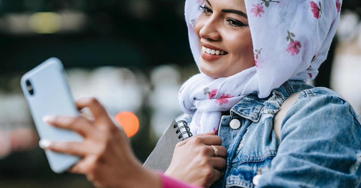 Cannot authenticate on phone [duplicate] - Cheerful Muslim woman taking selfie