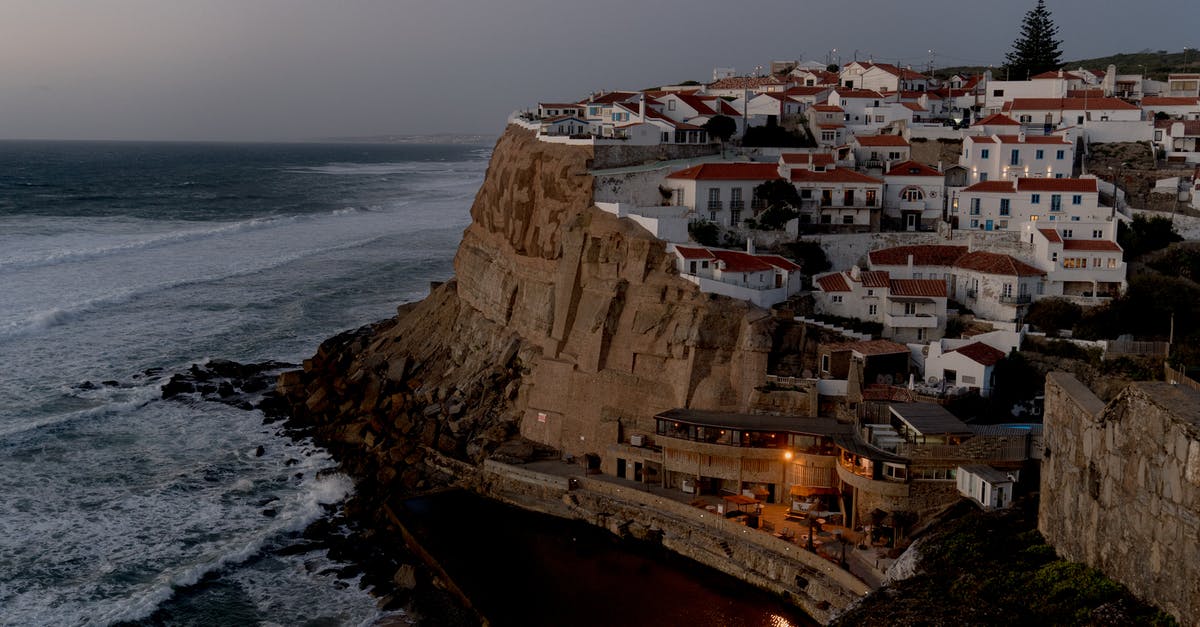 Cannot overwrite village what should I do? - Houses Perched on a Cliff Overlooking a Sandy Beach and Rocky Coastline 