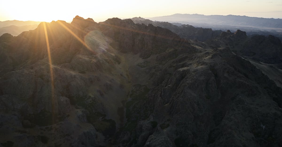 Castlevania Lords of Shadow last boss - Majestic drone view of mountain range almost plunged into darkness touched by last sunbeam of setting sun causing lens flare