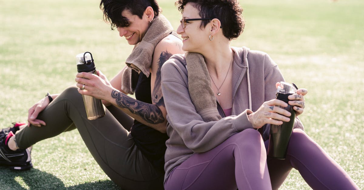 Chances of Hidden Ability through breeding, as well as chances for gender - Couple of thirsty athletic girlfriends talking and smiling while drinking water and sitting on grass on stadium in back lit in daylight
