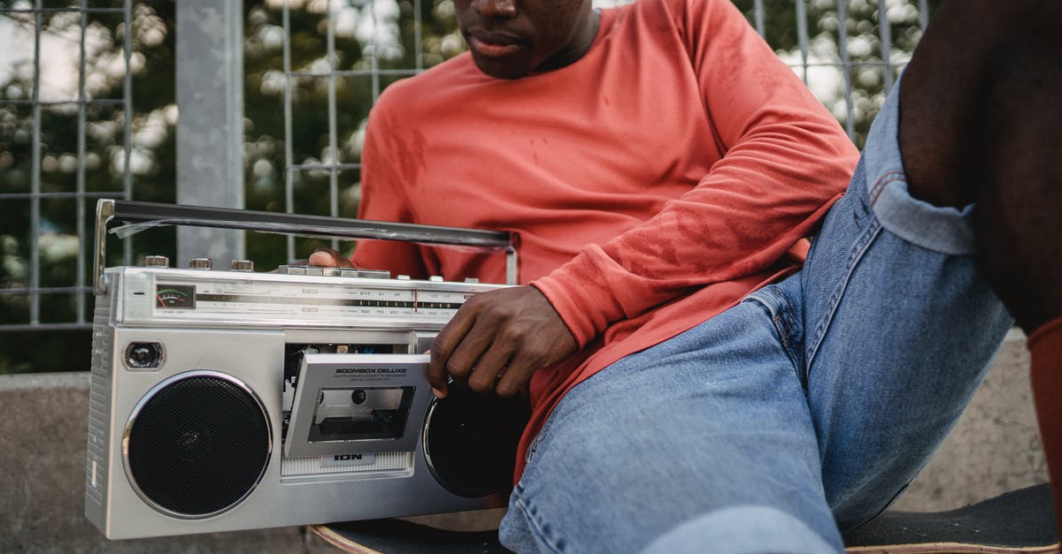 Change a scoreboard objective is a player gets within proximity of an entity? - Crop black man in casual clothes opening retro recorder to change cassette during resting on concrete surface with skateboard in city street