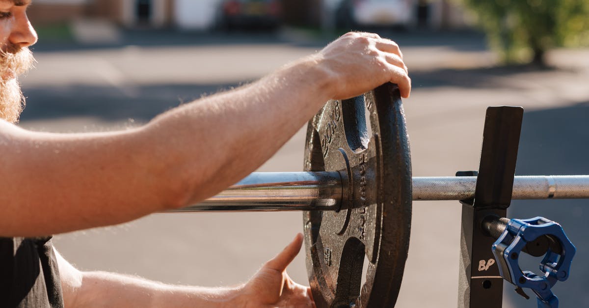 Change or swap fit skills damage with others - Man putting weight on metal barbell Change or swap fit skills damage with others - Man putting weight on metal barbell