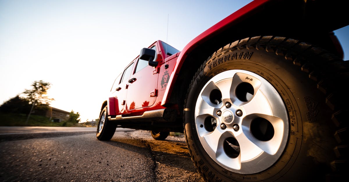 Changing the default driving view angle - Ground level of red all terrain vehicle standing on road in countryside at sunny day Changing the default driving view angle - Ground level of red all terrain vehicle standing on road in countryside at sunny day