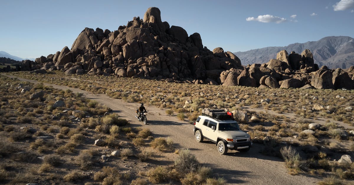 Changing the default driving view angle - Car driving near motorbike in mountainous area in semidesert Changing the default driving view angle - Car driving near motorbike in mountainous area in semidesert