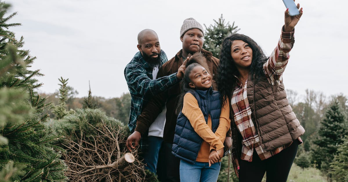 Changing Xbox settings from Adult to child or teen - Happy black family taking selfie on smartphone