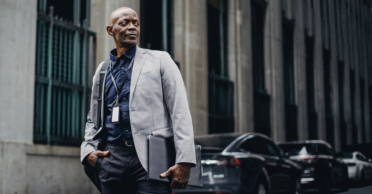 Cheating expert bosses - Serious adult African American businessman in formal suit standing with hand in pocket on urban street and looking away thoughtfully