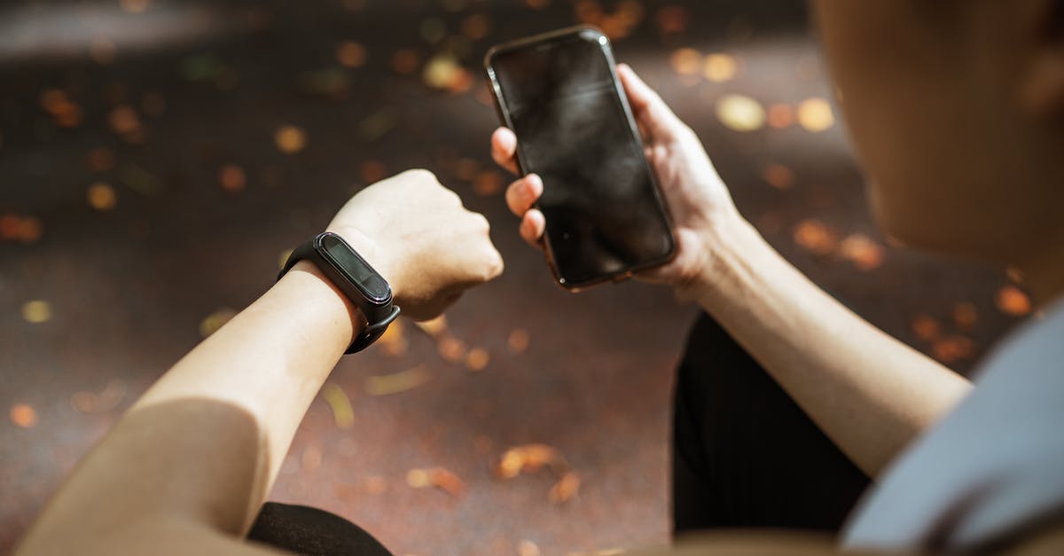 Check if a dlc is activated in the current campaign in xcom - Back view of anonymous female using smartphone app and smart watch after jogging in park