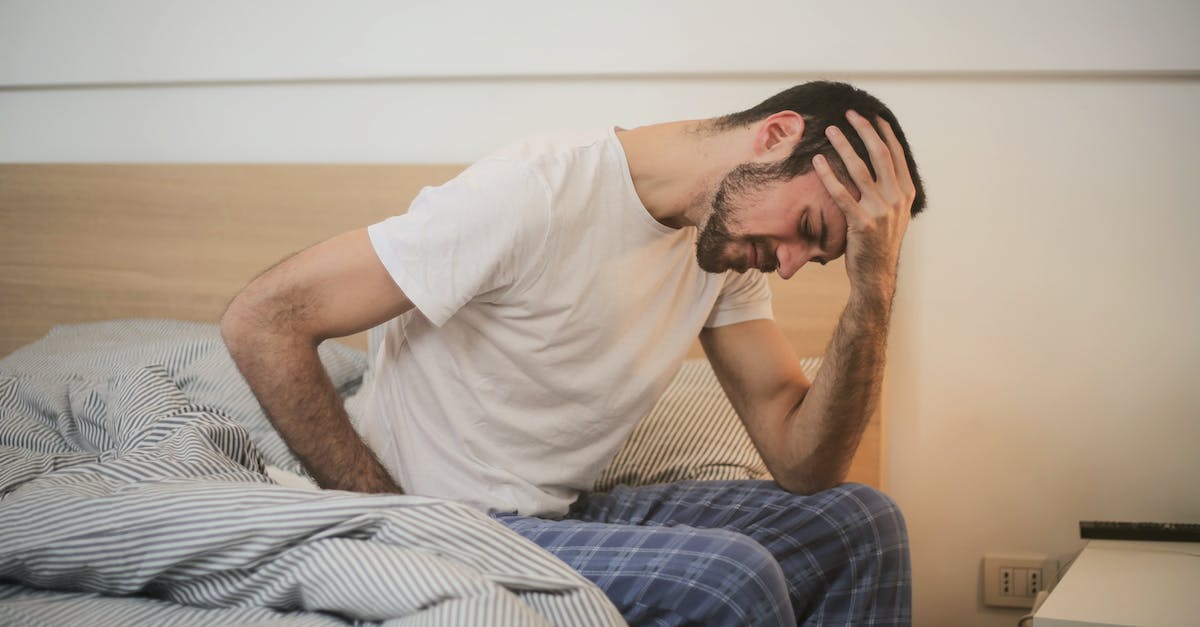 Chromaggus and fatigue - Young man in sleepwear suffering from headache in morning