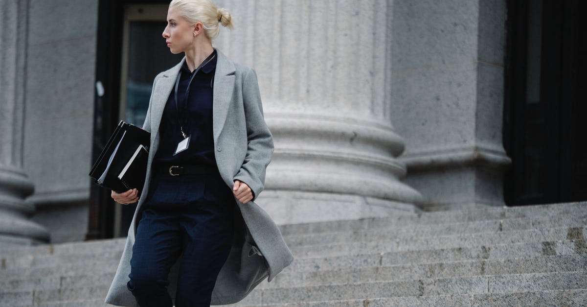 Civ V and City State Allies - Serious female lawyer in elegant outfit holding folders with documents while going downstairs near stone state building and looking away