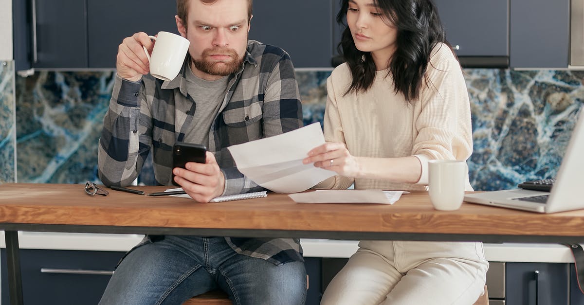 Clash of clans link problems - A Man Looking at the Paper while Holding a Coffee and Phone