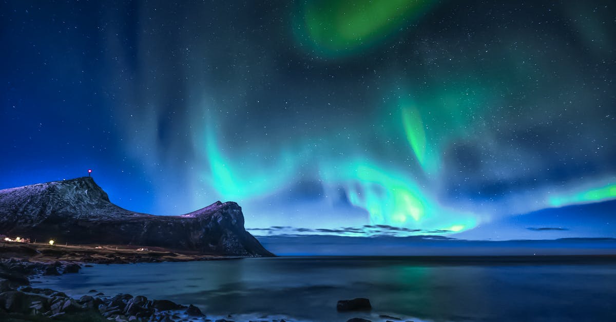 Clothing or stone houses for the winter? - Green Aurora Lights over Rocky Shore during Night Time