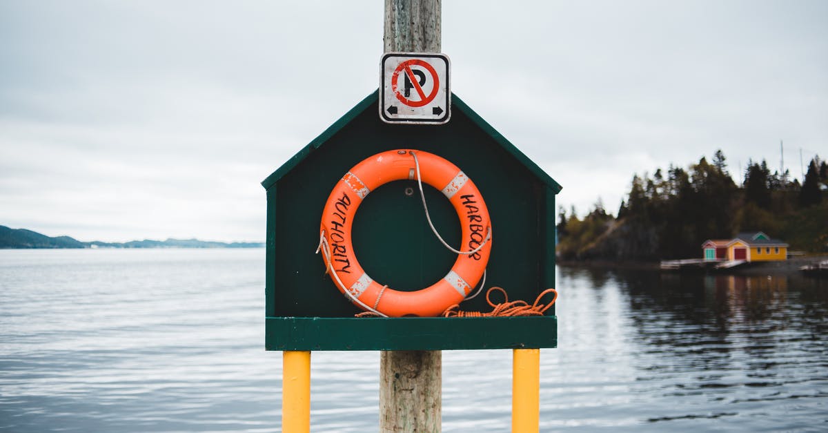 Cloud save issues - Colorful stand with red lifebuoy located on quay near peaceful rippling pond in countryside on cloudy day Cloud save issues - Colorful stand with red lifebuoy located on quay near peaceful rippling pond in countryside on cloudy day