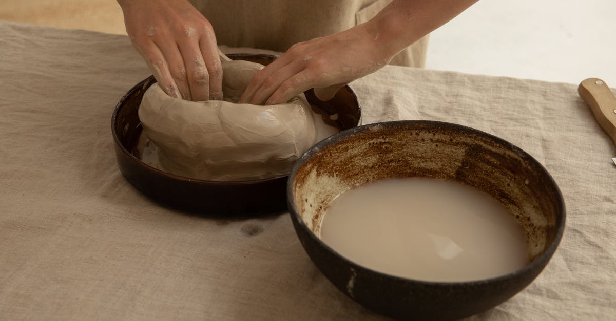 Coalesced for credits in Mass Effect 3 not working - From above of crop anonymous artisan sculpting soft clay near bowl with liquid on table in workroom