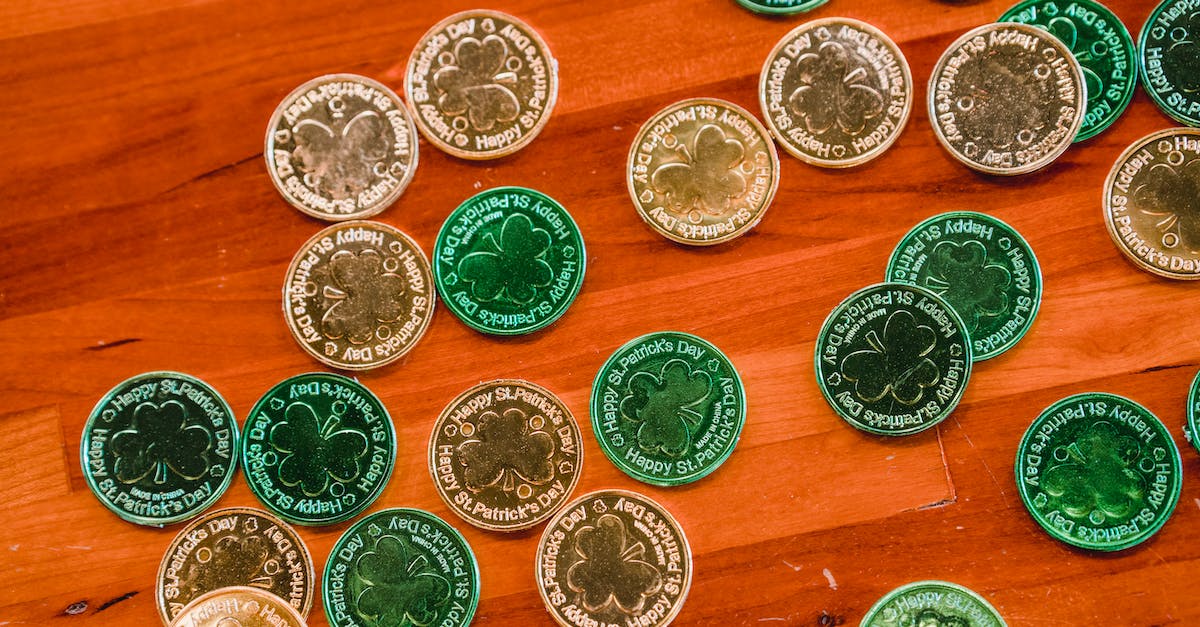 Coin changes to 3-leaf clover after playing sometime - Many St Patricks day coins placed on brown wooden floor