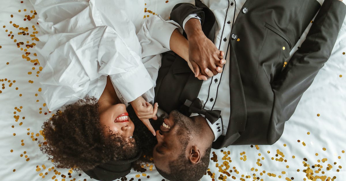 Colossatron & Mr. Cuddles - A Couple Lying on the Bed While Holding Hands