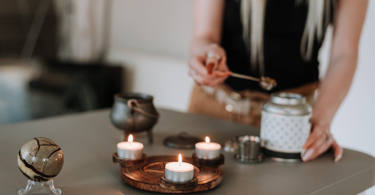Commander Caius isn't there for the tasting ceremony during dampened spirits - Woman preparing incense near shiny candles