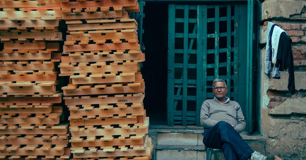 Company of Heroes and Company of Heroes tales of valor - Man Sitting in Front of a Building with a Stack of Pallets Next to Him 