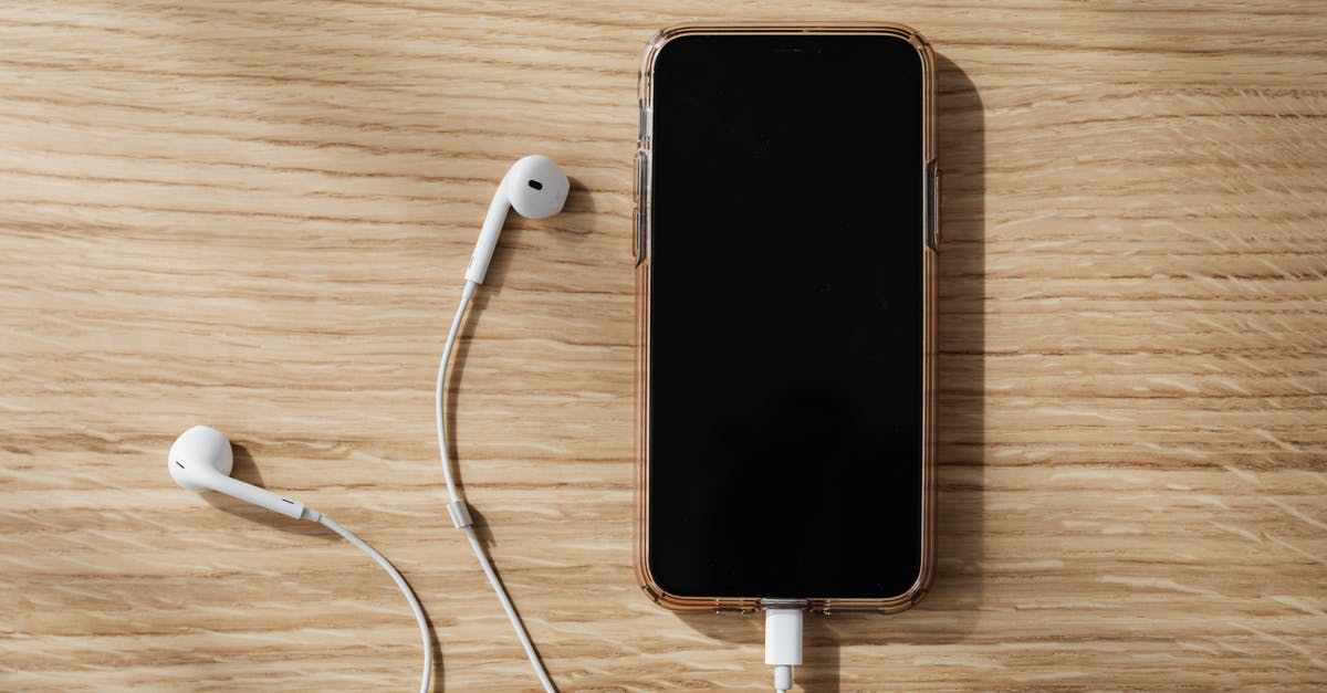 Connect Nintendo 64 to a modern flat-screen TV? - Charging smartphone and white earphones on wooden table Connect Nintendo 64 to a modern flat-screen TV? - Charging smartphone and white earphones on wooden table