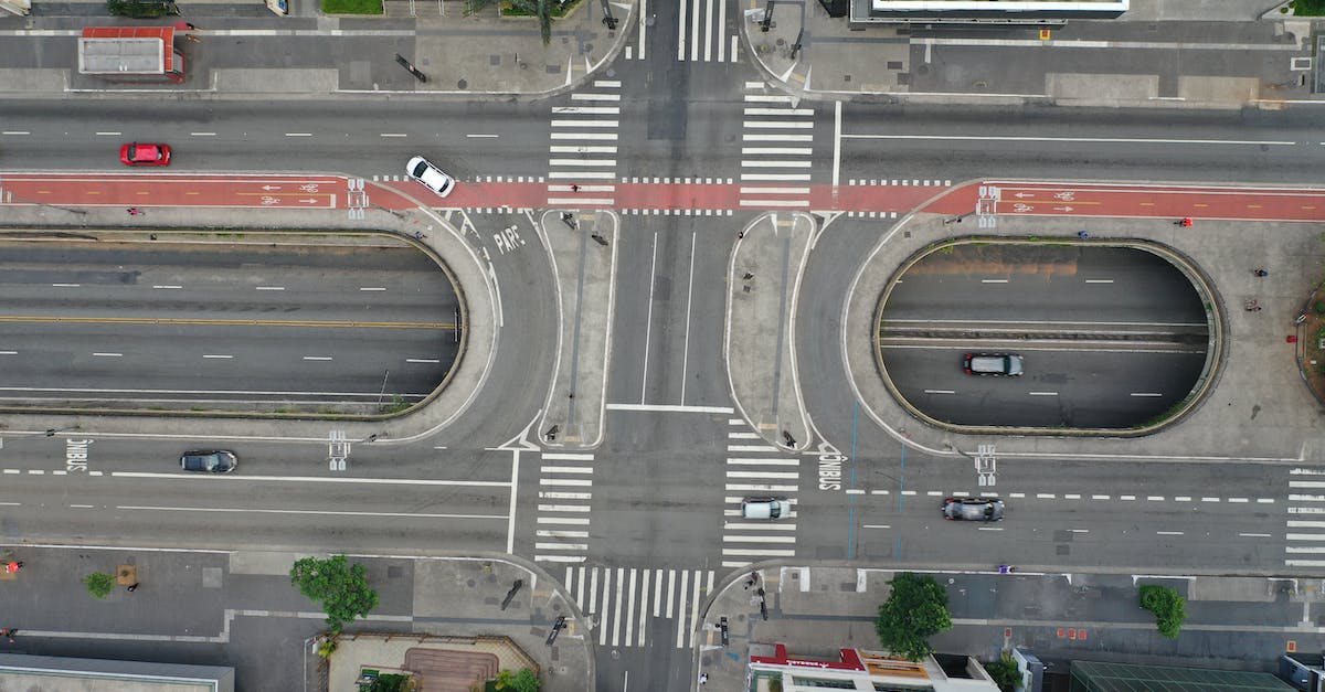 Connect to highway coming from outside city limits [duplicate] - Drone view cars driving on large modern asphalt road with pedestrian crossing in daytime
