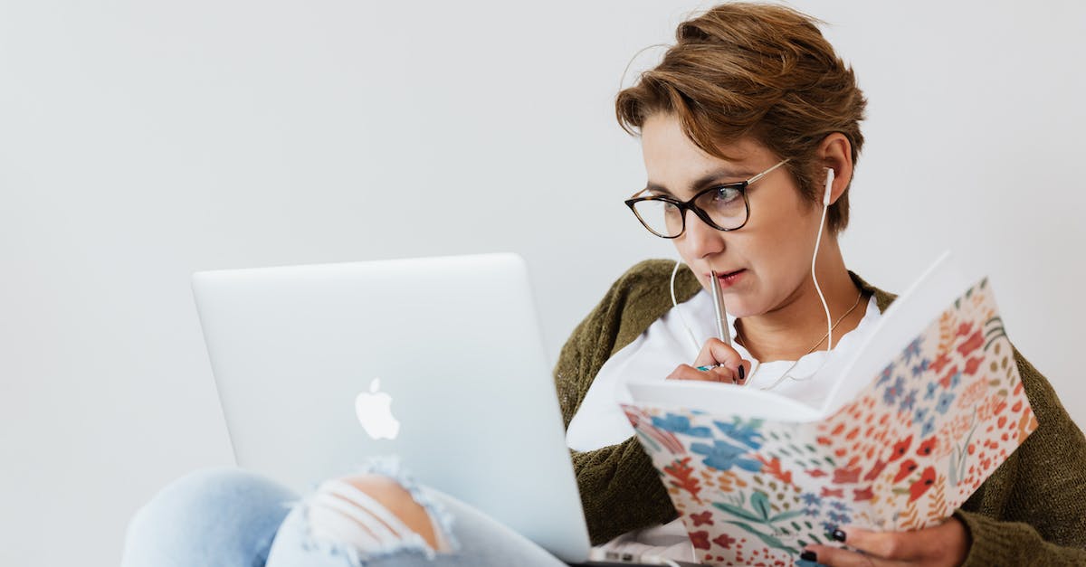 Connecting a Wii to a HD TV using coloured pins - Concentrated woman using laptop and taking notes