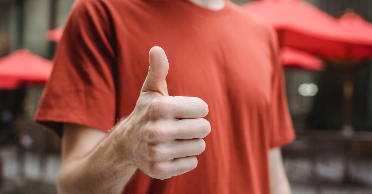 Console commands don't show up as letters, but as square symbols - Crop anonymous young male in red t shirt showing thumb up gesture while standing on city street on sunny day