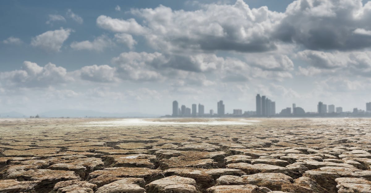 Contested Territory on iOS Bloons City - Vast territory of dried soil with contemporary buildings and skyscrapers on background on cloudy sunny day